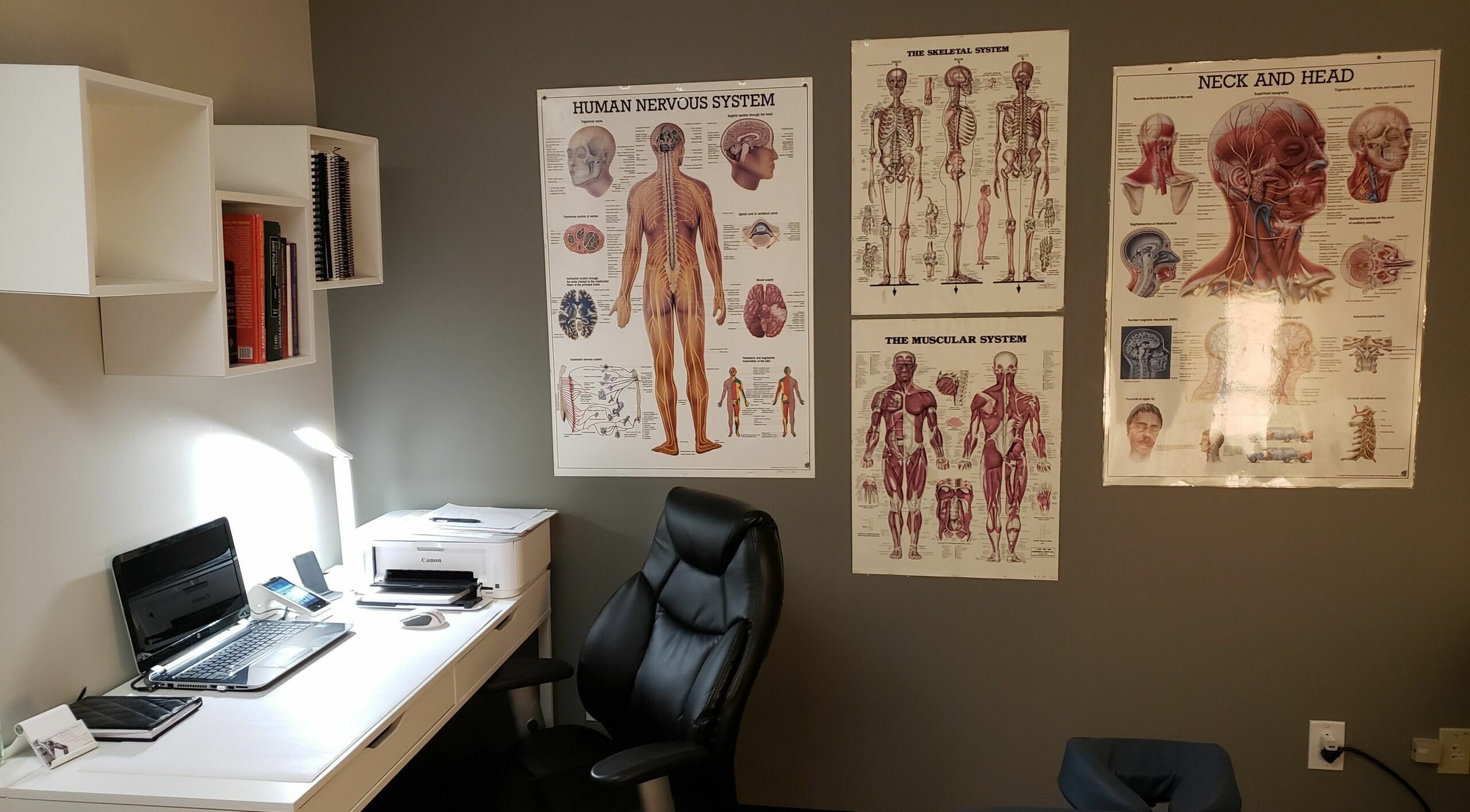 Cozy therapy office at Piotr Gorecki Manual Therapy Clinic Inc., Calgary, Alberta, CA, featuring anatomical charts.