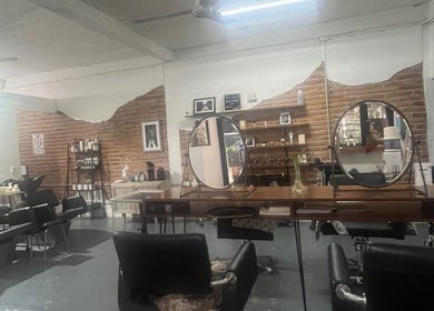Interior rústico de Spiral Hair Studio Leslie Panini en Puerto Vallarta, Jalisco, MX con espejos y estaciones de trabajo.