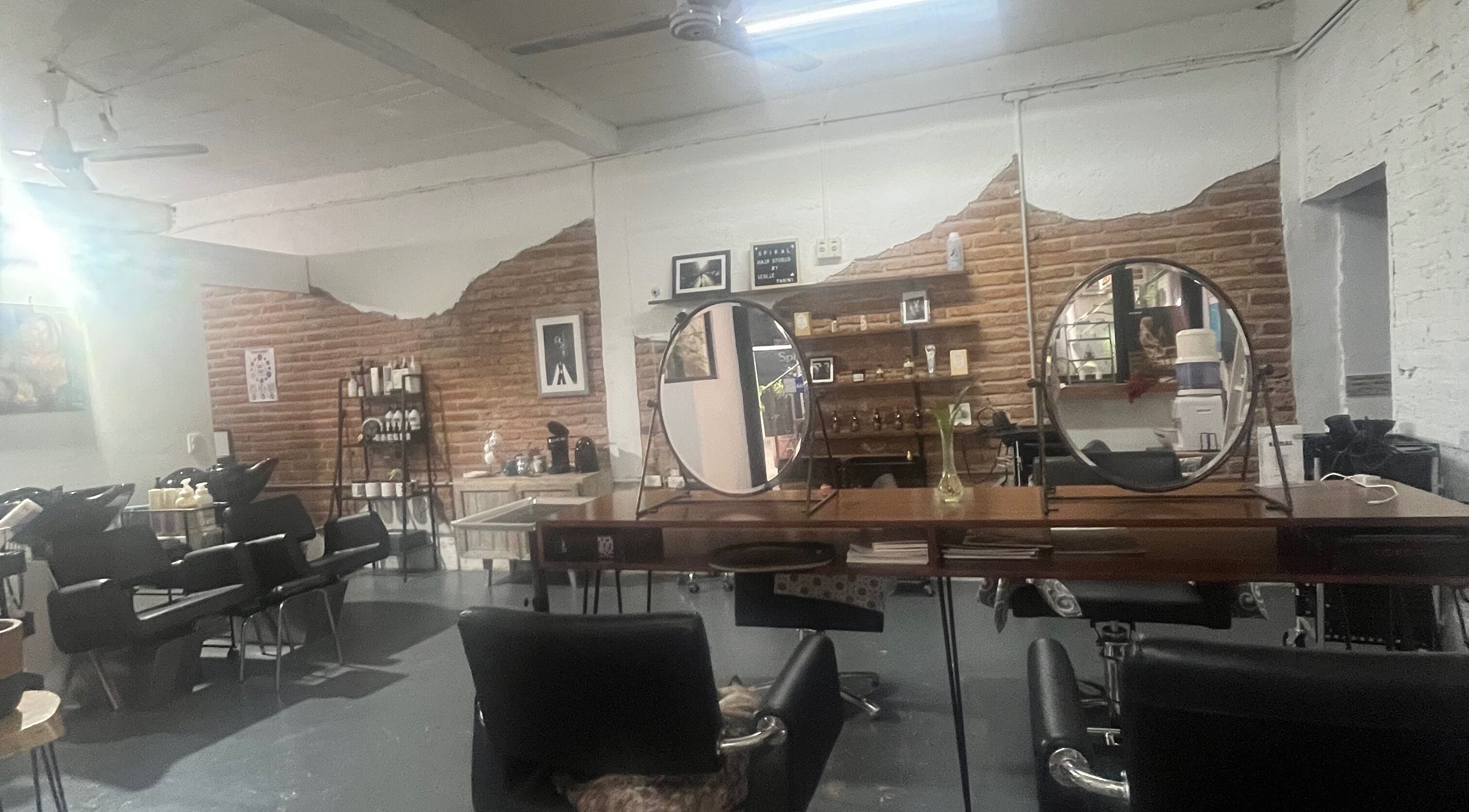 Interior rústico de Spiral Hair Studio Leslie Panini en Puerto Vallarta, Jalisco, MX con espejos y estaciones de trabajo.