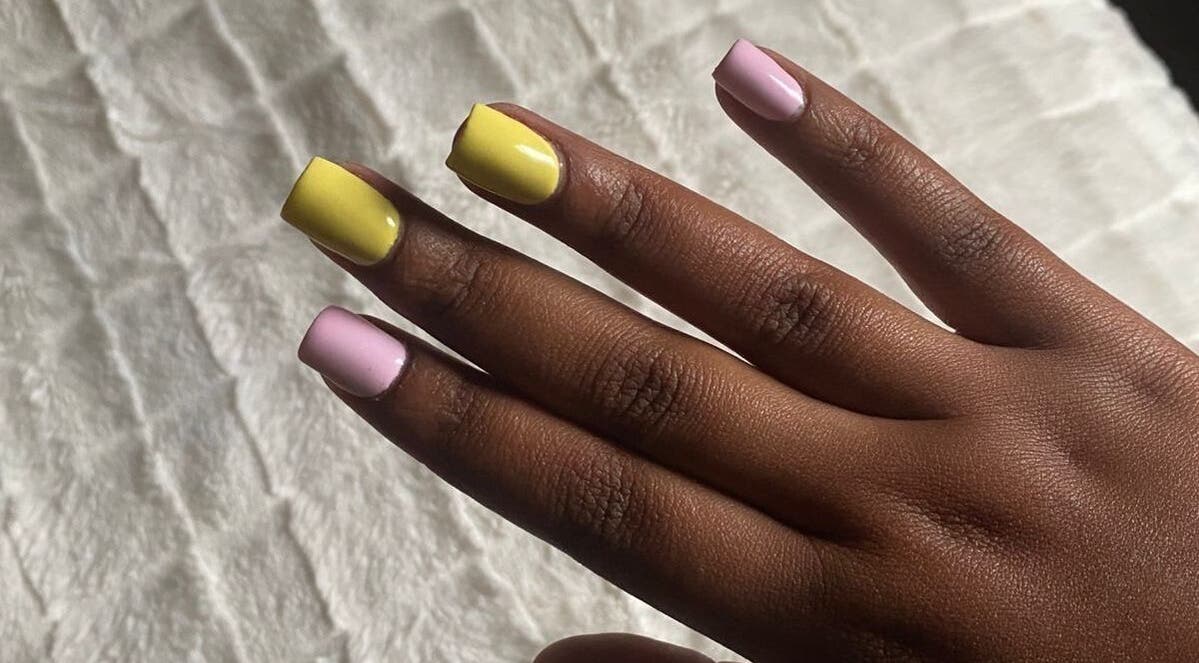 Stylish pastel nails at Sphe’s nail studio, East London, ZA. Yellow and pink manicure on dark skin.