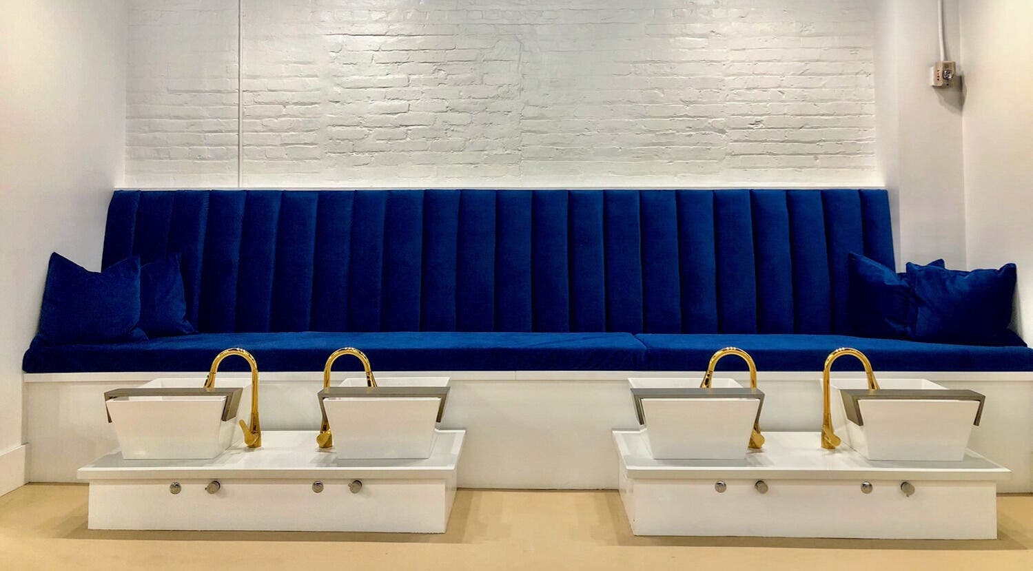 Elegant blue seating with gold sinks at Eversaint Salon in New Orleans, Louisiana, US.