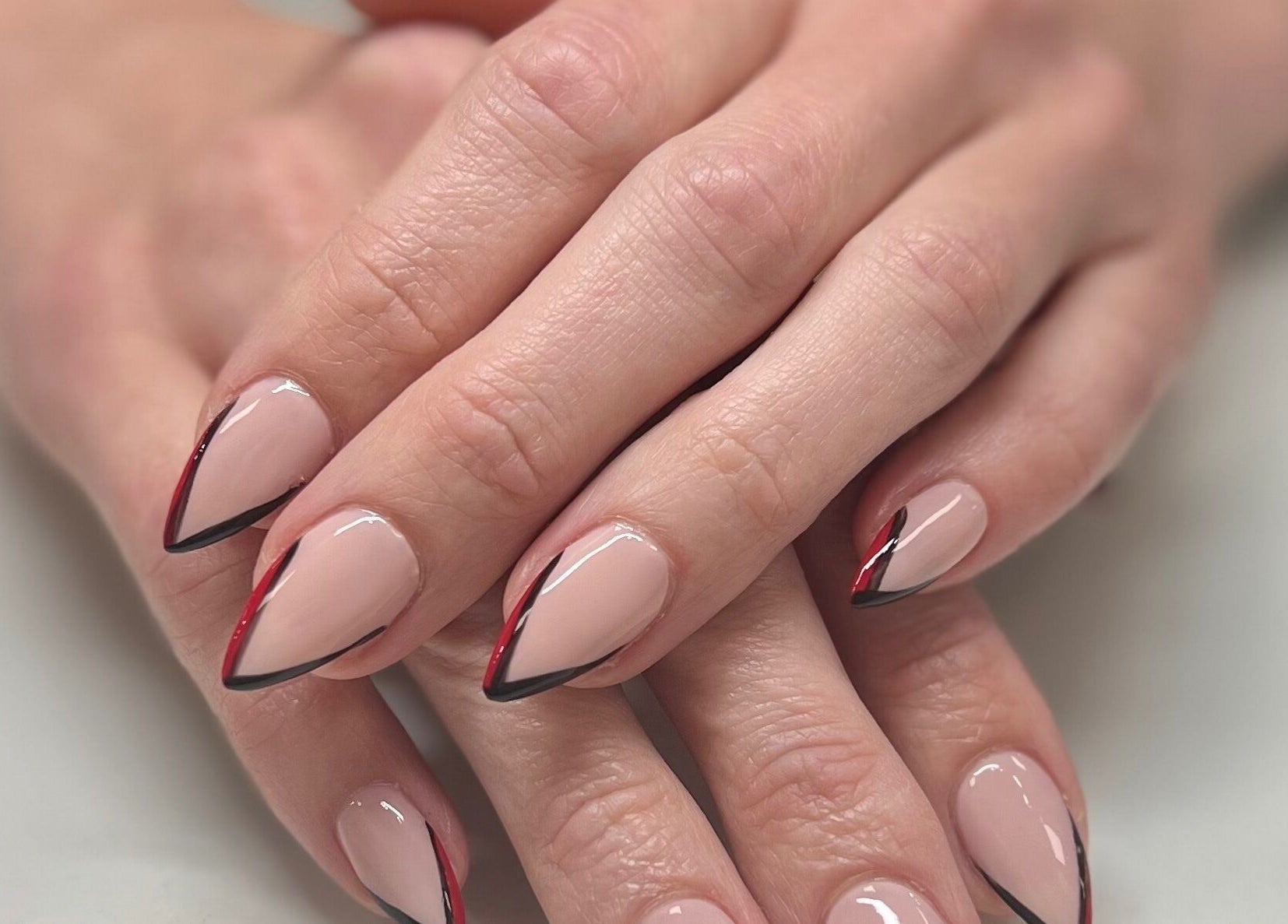 Elegant nail art at Eversaint Salon, New Orleans, Louisiana, US. Features stylish red and black accents.
