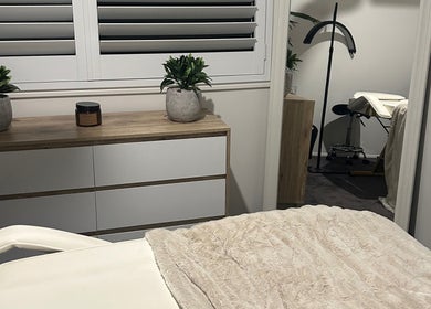 Serene treatment room at Aura Wellness Studio in Reedy Creek, Queensland, AU, featuring cozy decor and massage bed.