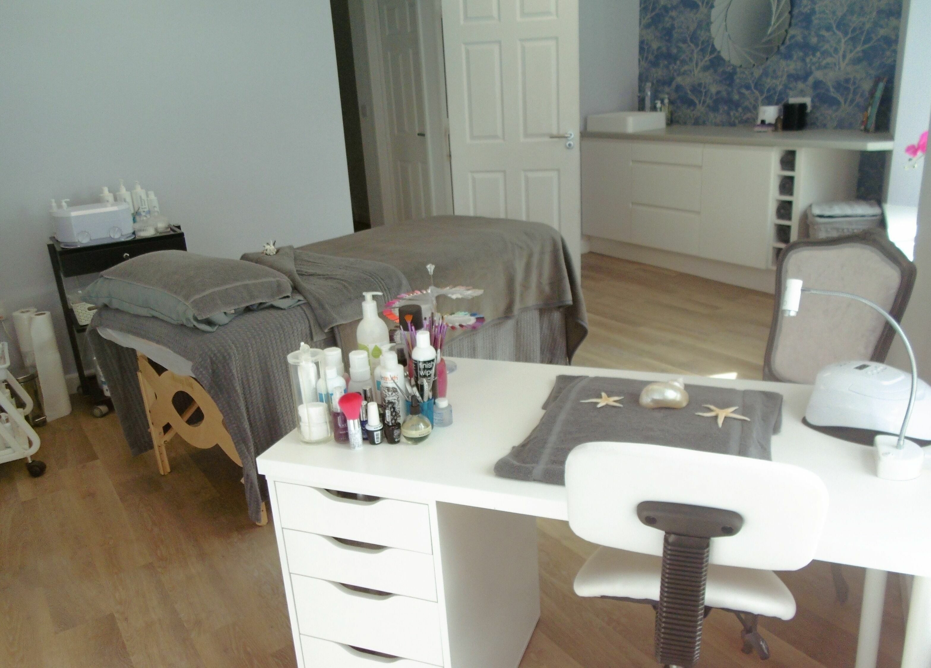 Relaxing spa treatment room at Serenity On The Square in Holsworthy, England, GB, with massage table and products.