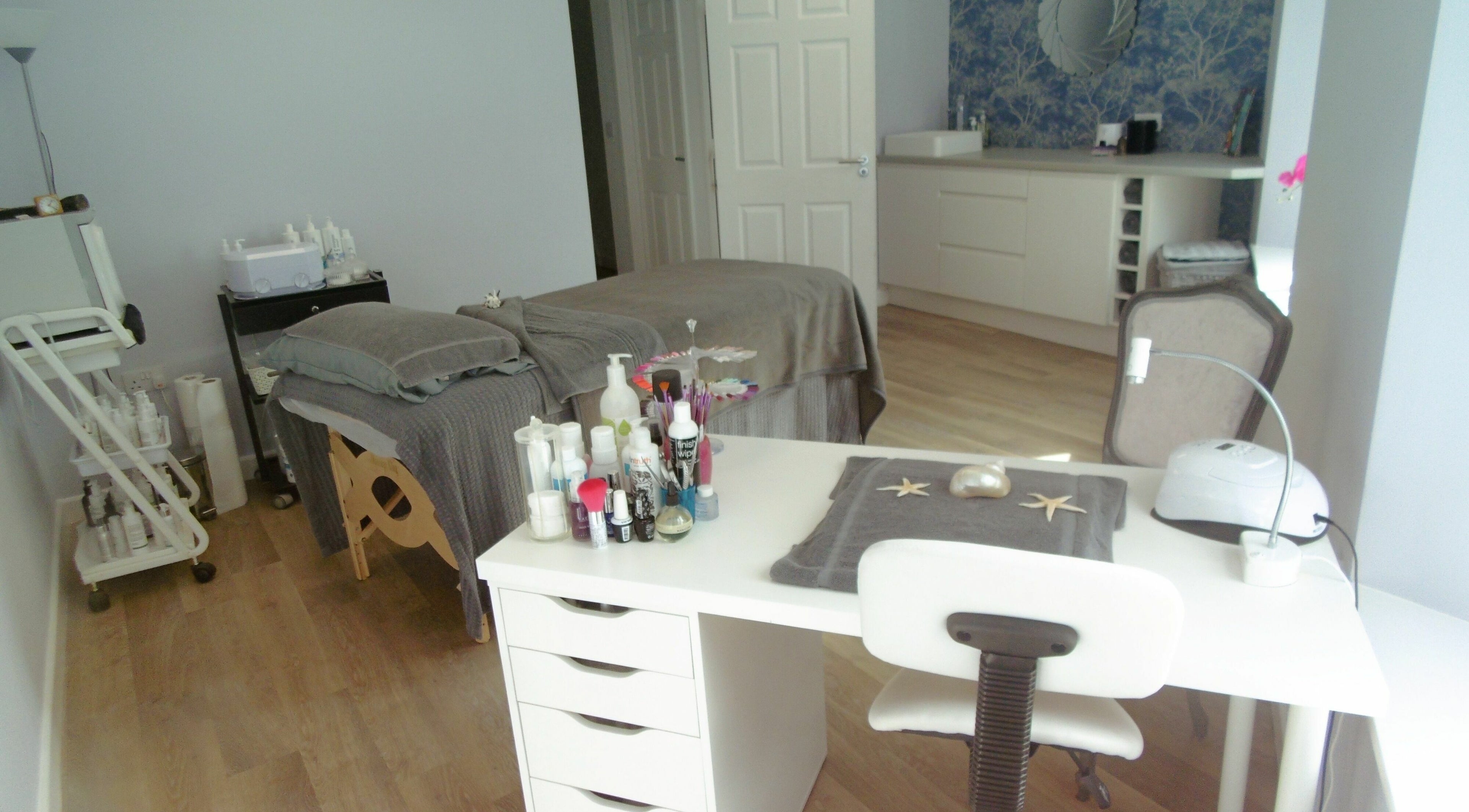 Relaxing spa treatment room at Serenity On The Square in Holsworthy, England, GB, with massage table and products.