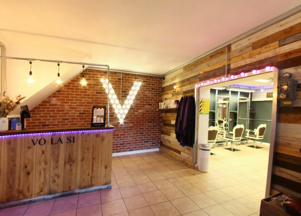 Reception area of Vo La Si, Guisborough, England, GB with wooden decor and ambient lighting.