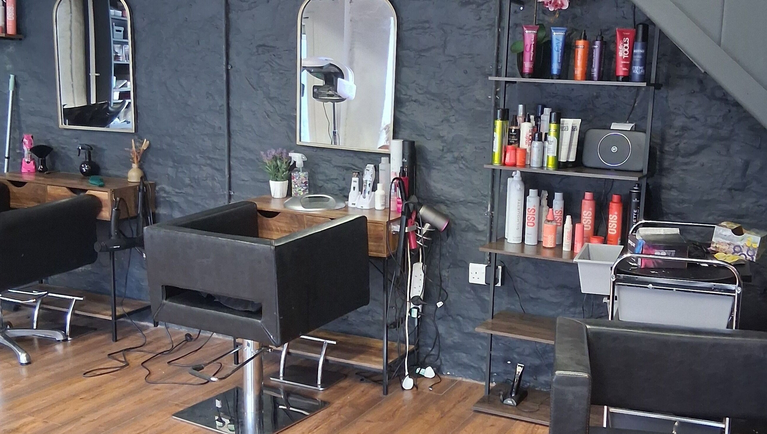 Modern salon interior at Hair By Joy, Lockerbie, Scotland, GB featuring sleek chairs and beauty products.