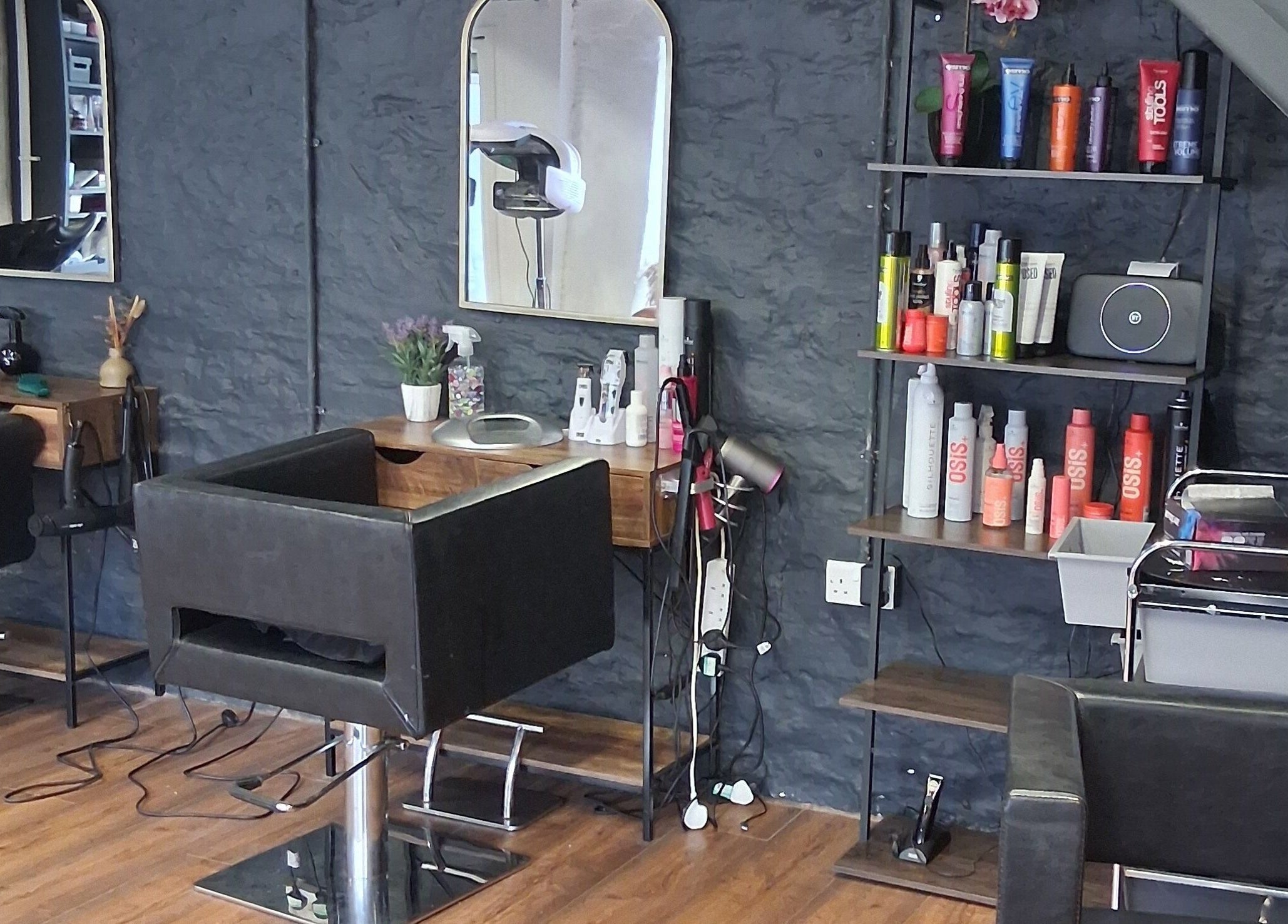 Modern salon interior at Hair By Joy, Lockerbie, Scotland, GB featuring sleek chairs and beauty products.