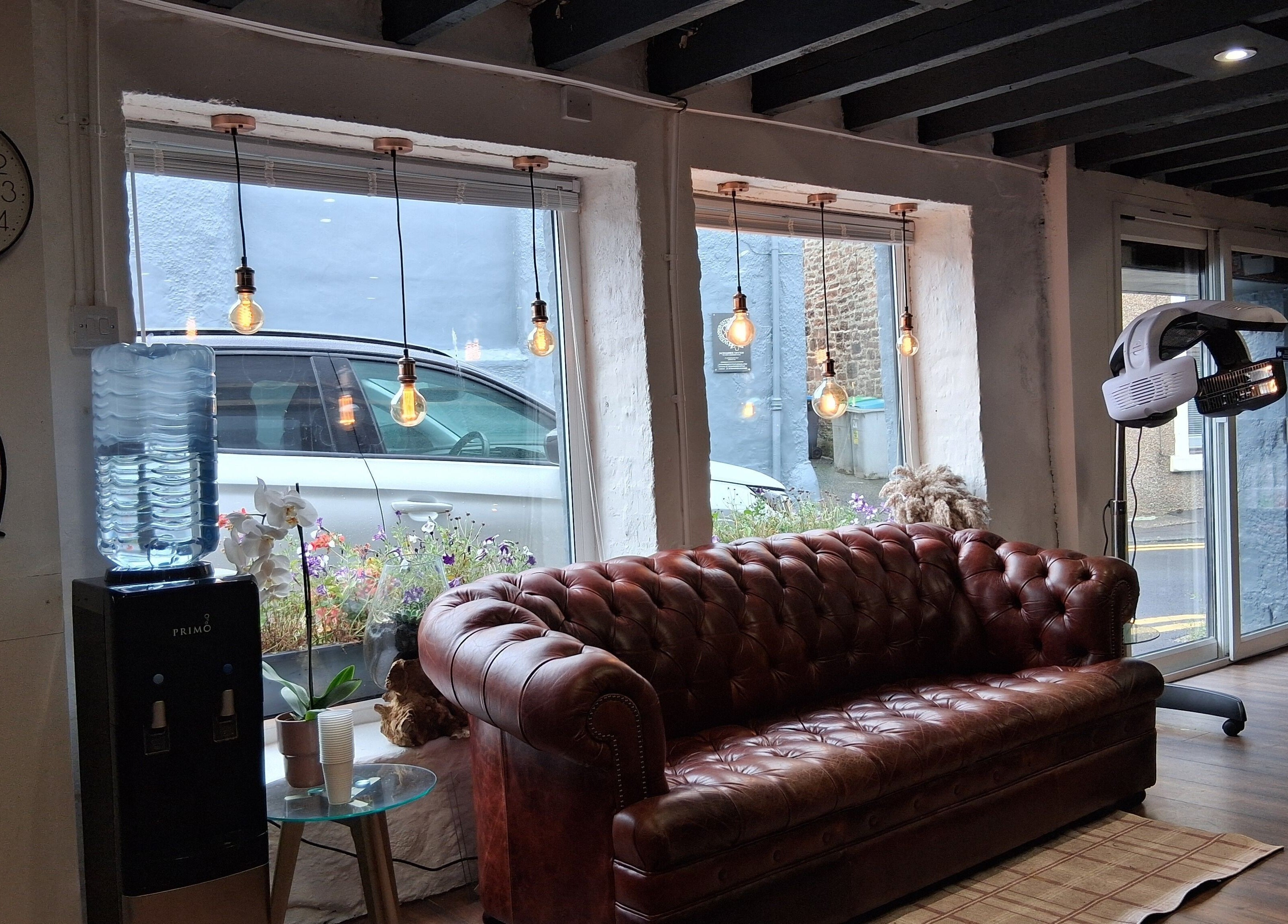 Cozy seating and decor at Hair By Joy, Lockerbie, Scotland, GB with vintage sofa and warm lighting.