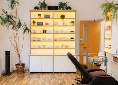 Mg Skincare beauty studio at TOWER BRIDGE LONDON, England. Display shelves with products and green plants.