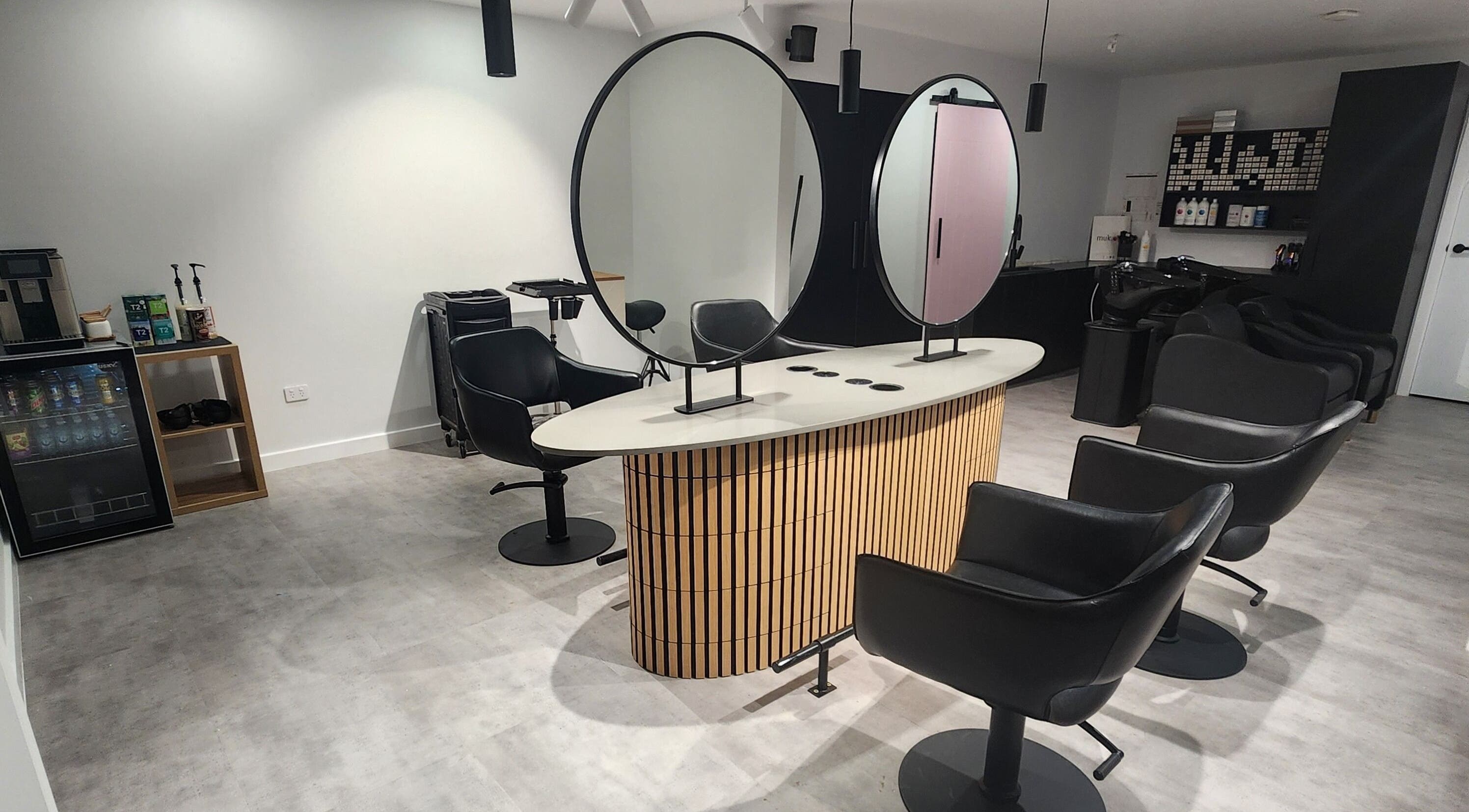 Elegant styling area at Vallee Hair Co, Mulbring, NSW, AU, with modern chairs and mirrors.
