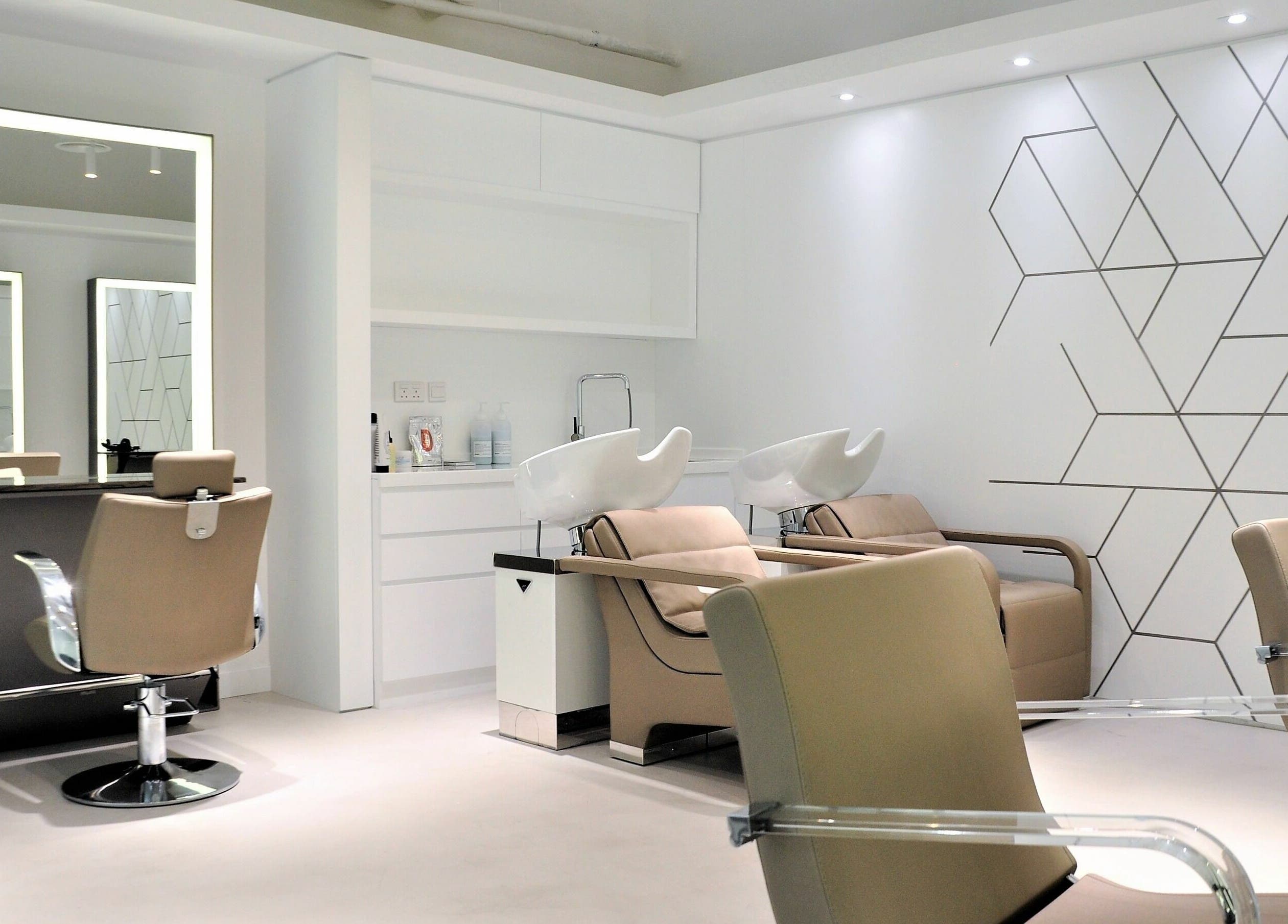 Modern salon interior at Definition - The Hair Expert in Abu Dhabi, showcasing stylish chairs and wash stations.