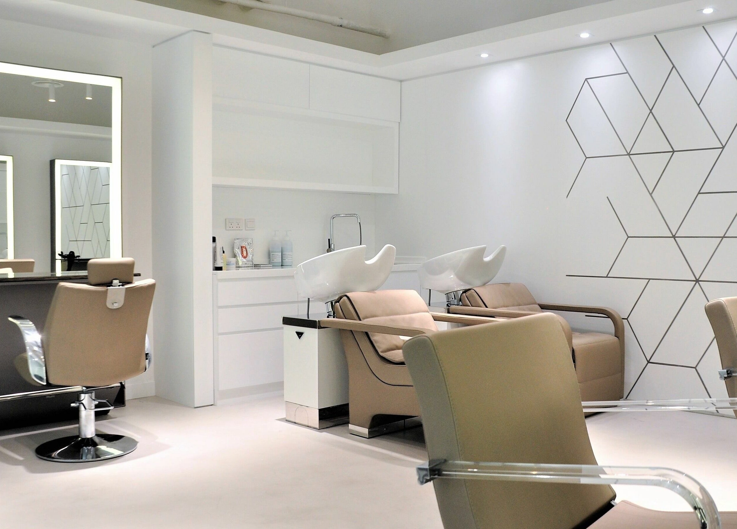 Modern salon interior at Definition - The Hair Expert in Abu Dhabi, showcasing stylish chairs and wash stations.