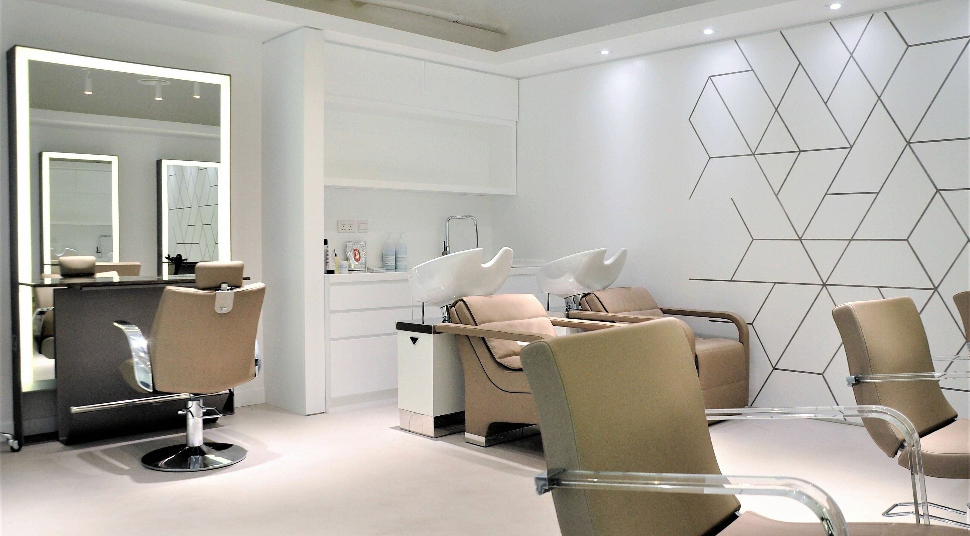 Modern salon interior at Definition - The Hair Expert in Abu Dhabi, showcasing stylish chairs and wash stations.