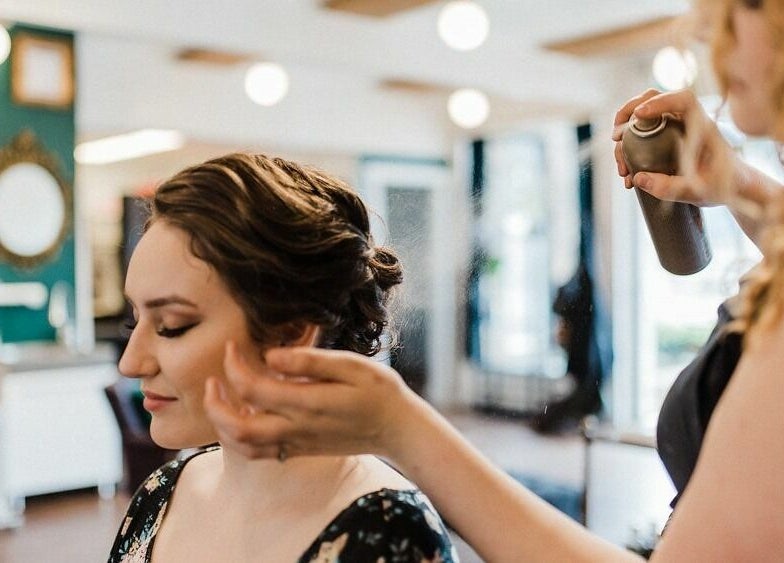 Hair stylist at Darling and Dapper Salon and Spa in Abbotsford, BC, creates flawless look with finishing spray.