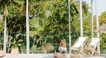 Woman meditating outdoors at Her Wellness Space, Biggera Waters, Queensland, AU surrounded by tropical greenery.