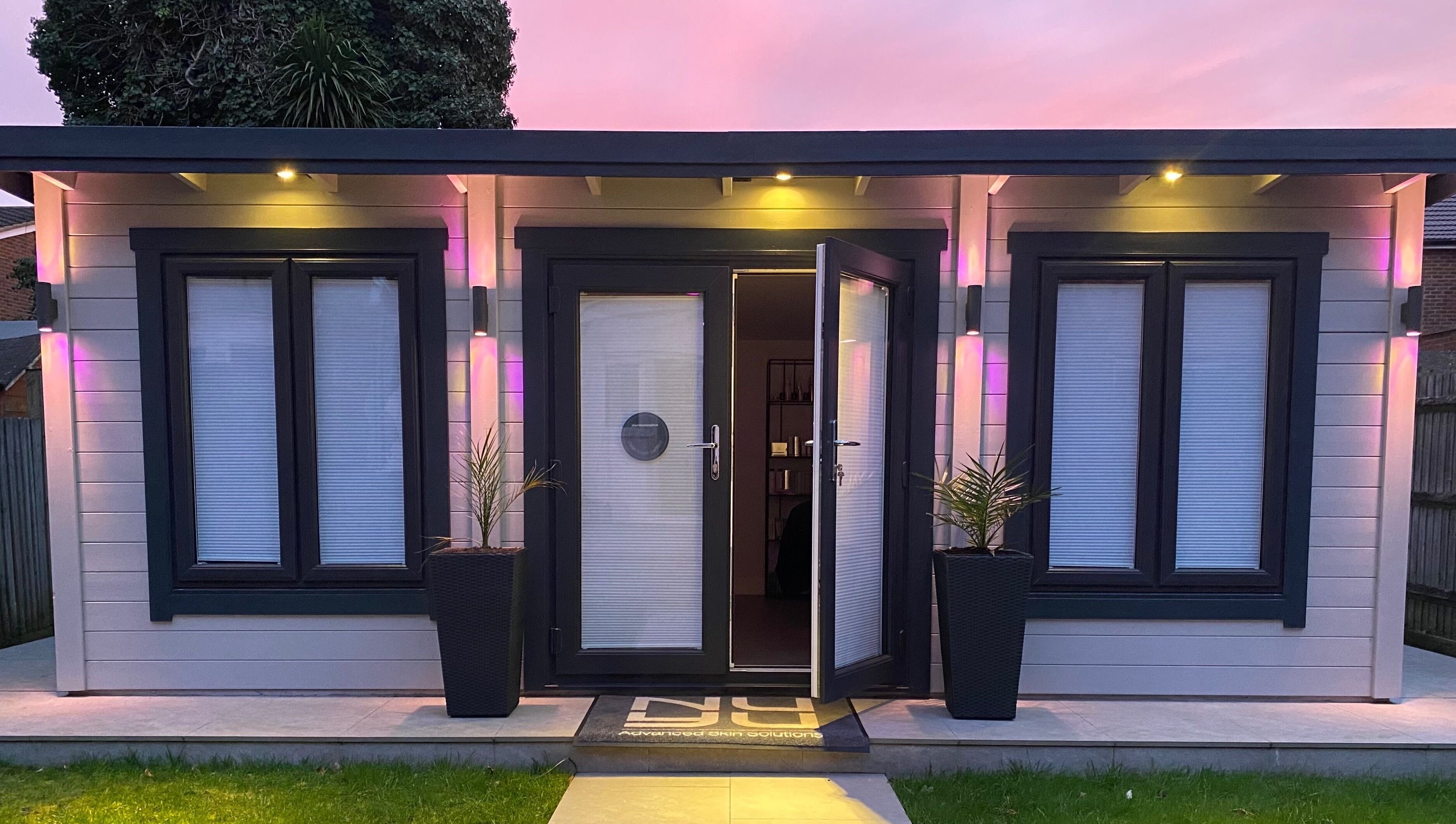 Nu-Yu Advanced Skin Solutions' illuminated entrance in Sidcup, England, GB at dusk with vibrant lighting.