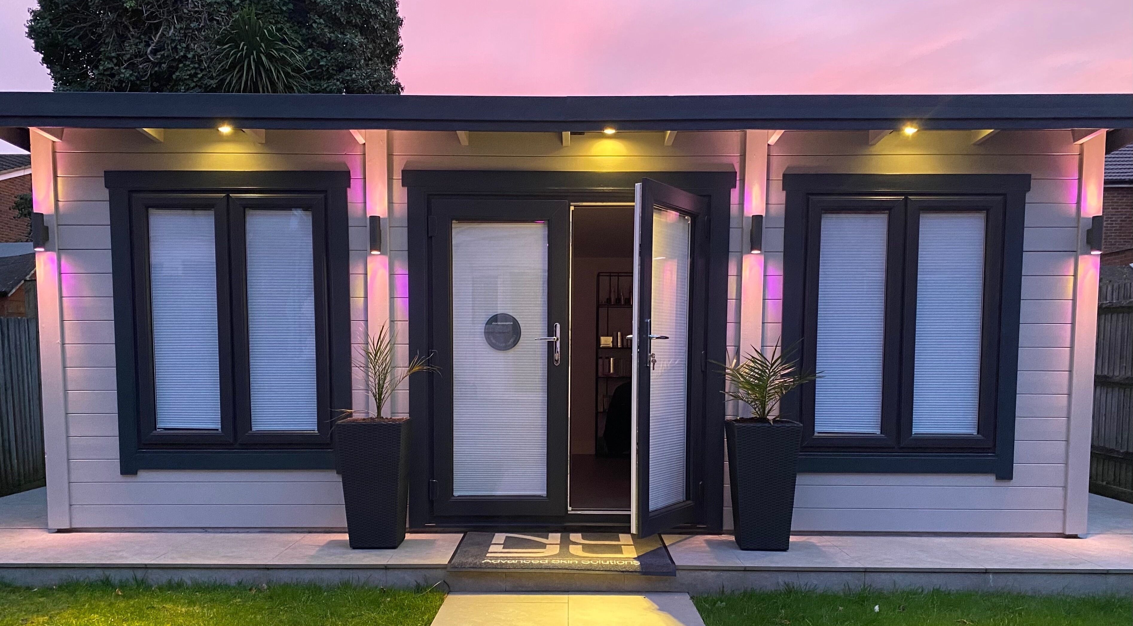 Nu-Yu Advanced Skin Solutions' illuminated entrance in Sidcup, England, GB at dusk with vibrant lighting.