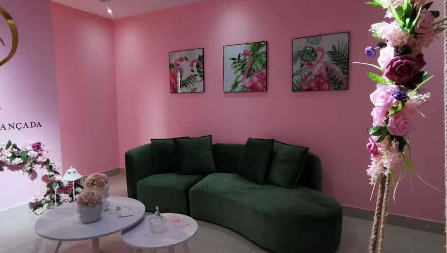 Sala com sofá verde e decoração floral no Rostos em Luanda, Luanda, AO.