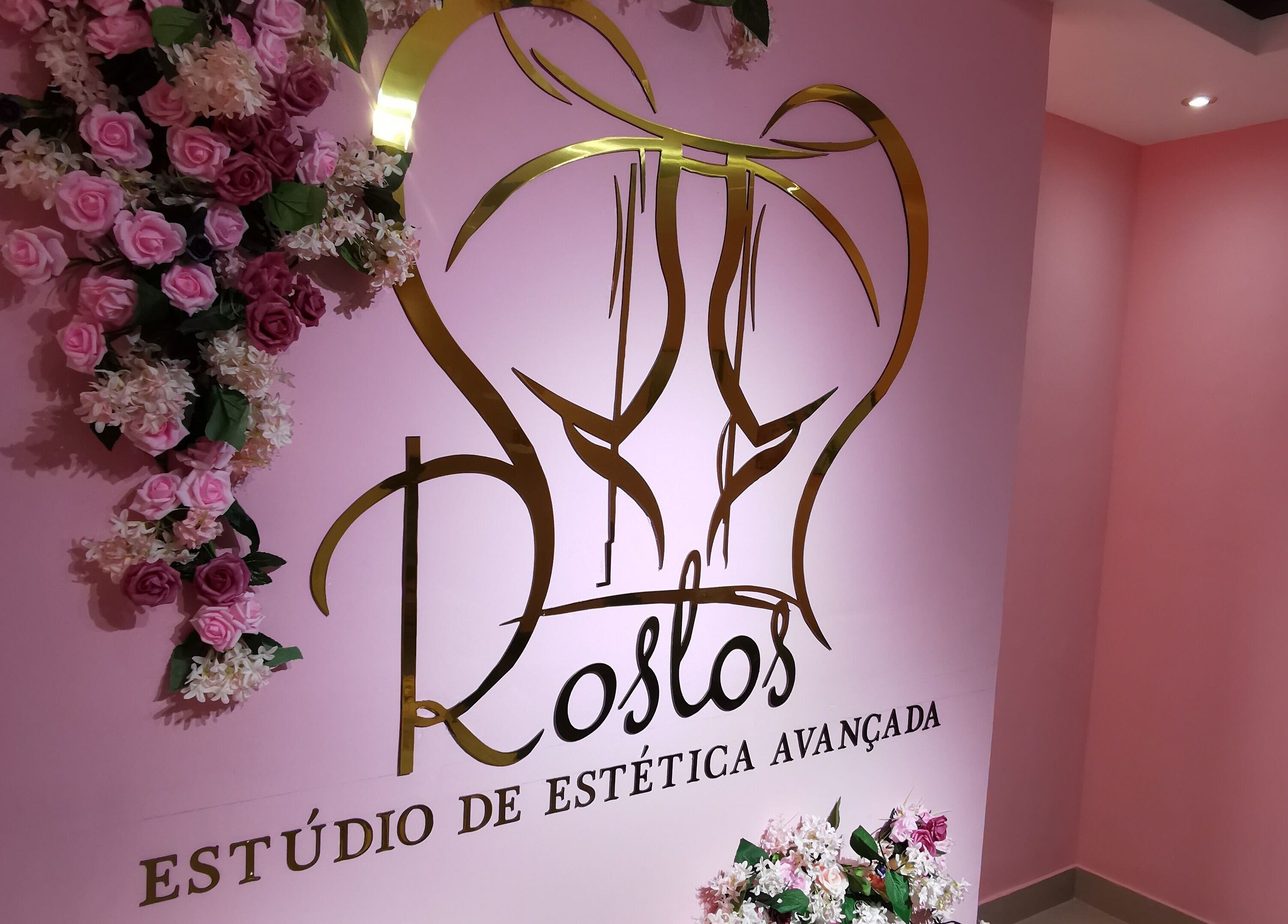 Entrada decorativa do estúdio Rostos em Luanda, Luanda, AO com flores e logo sofisticado.