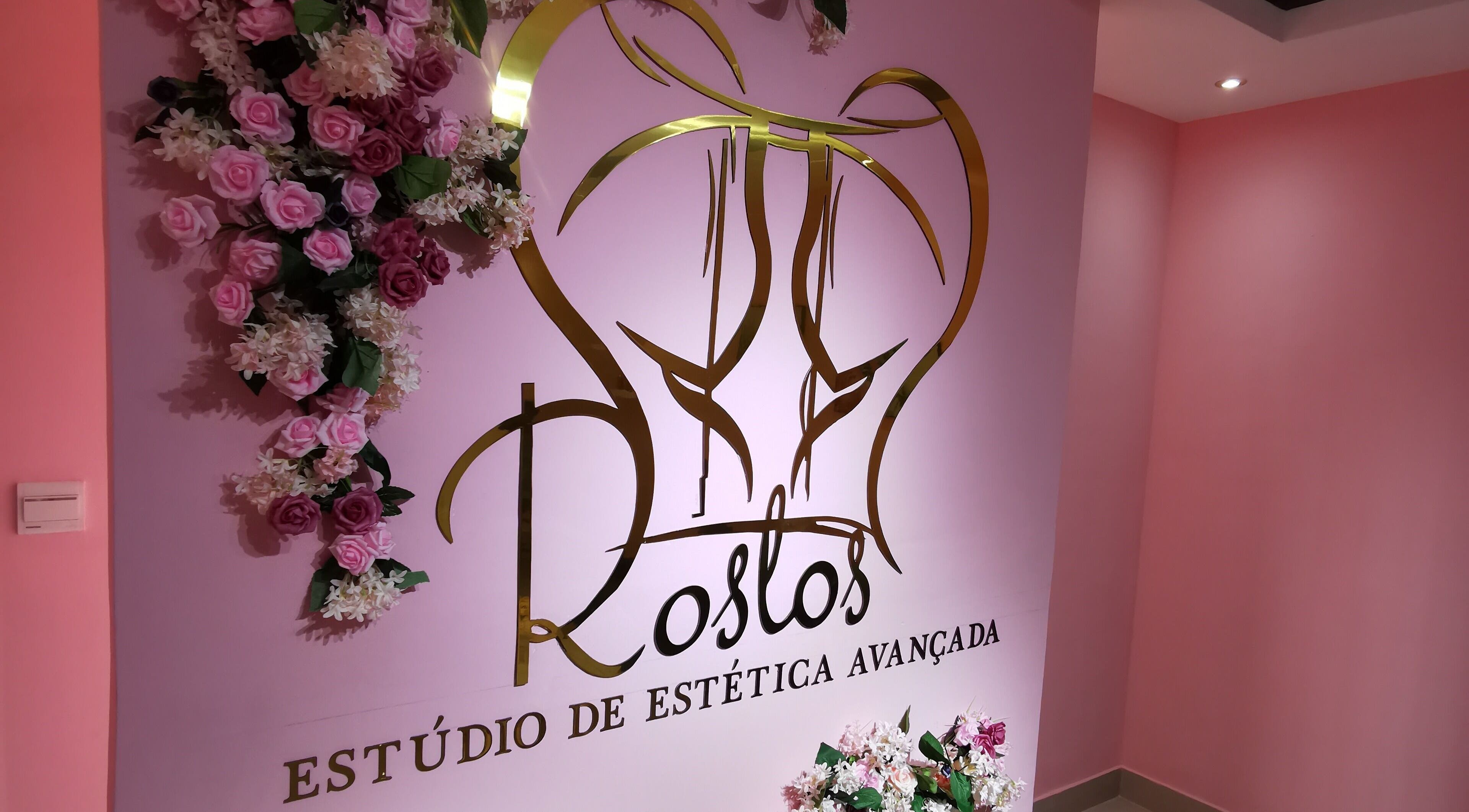 Entrada decorativa do estúdio Rostos em Luanda, Luanda, AO com flores e logo sofisticado.