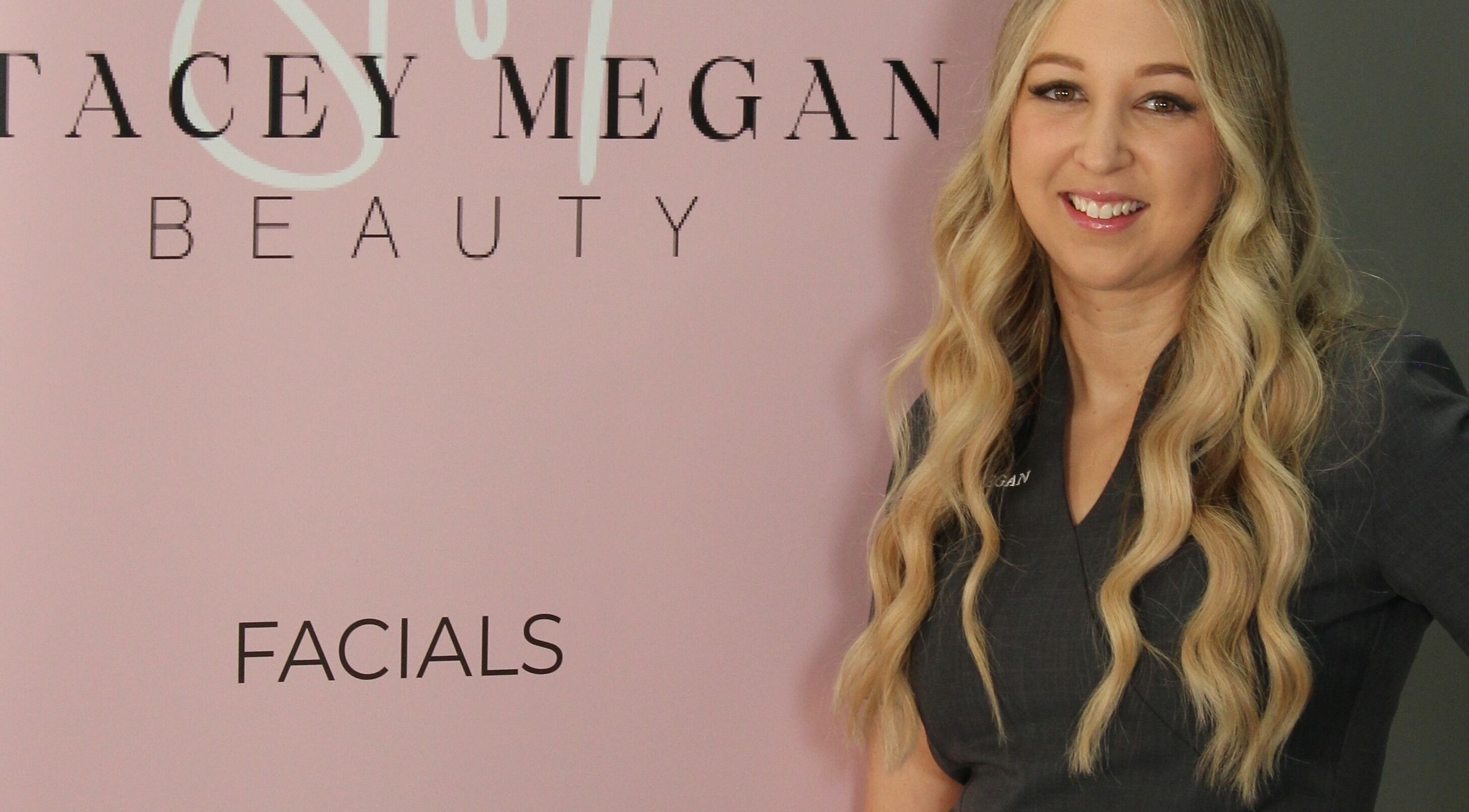 Stacey Megan Beauty expert in front of pink sign in Galston, New South Wales, AU.