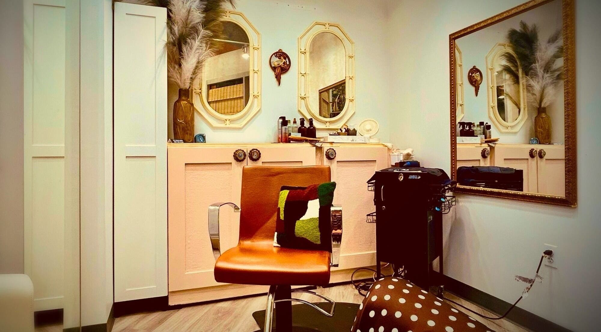 Elegant salon chair and mirrors at Glendale Arts+Salon in Chicago, Illinois, US. Cozy and stylish decor.