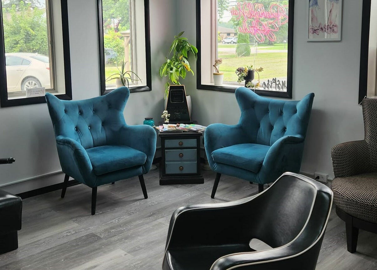 Stylish seating area in Revival Hair Studio, Onsted, Michigan, US with blue armchairs and decor.