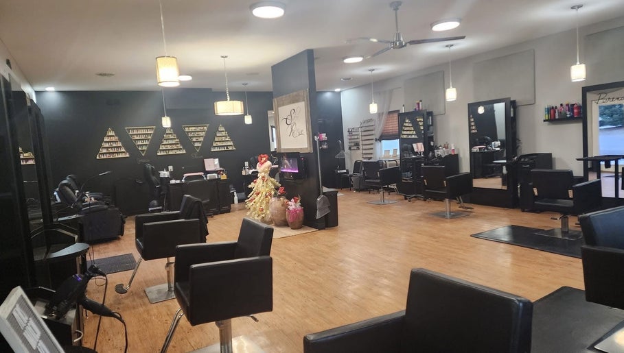 Spacious salon interior at Starrlight Beauty in Minerva, Ohio, featuring sleek black chairs and elegant decor.