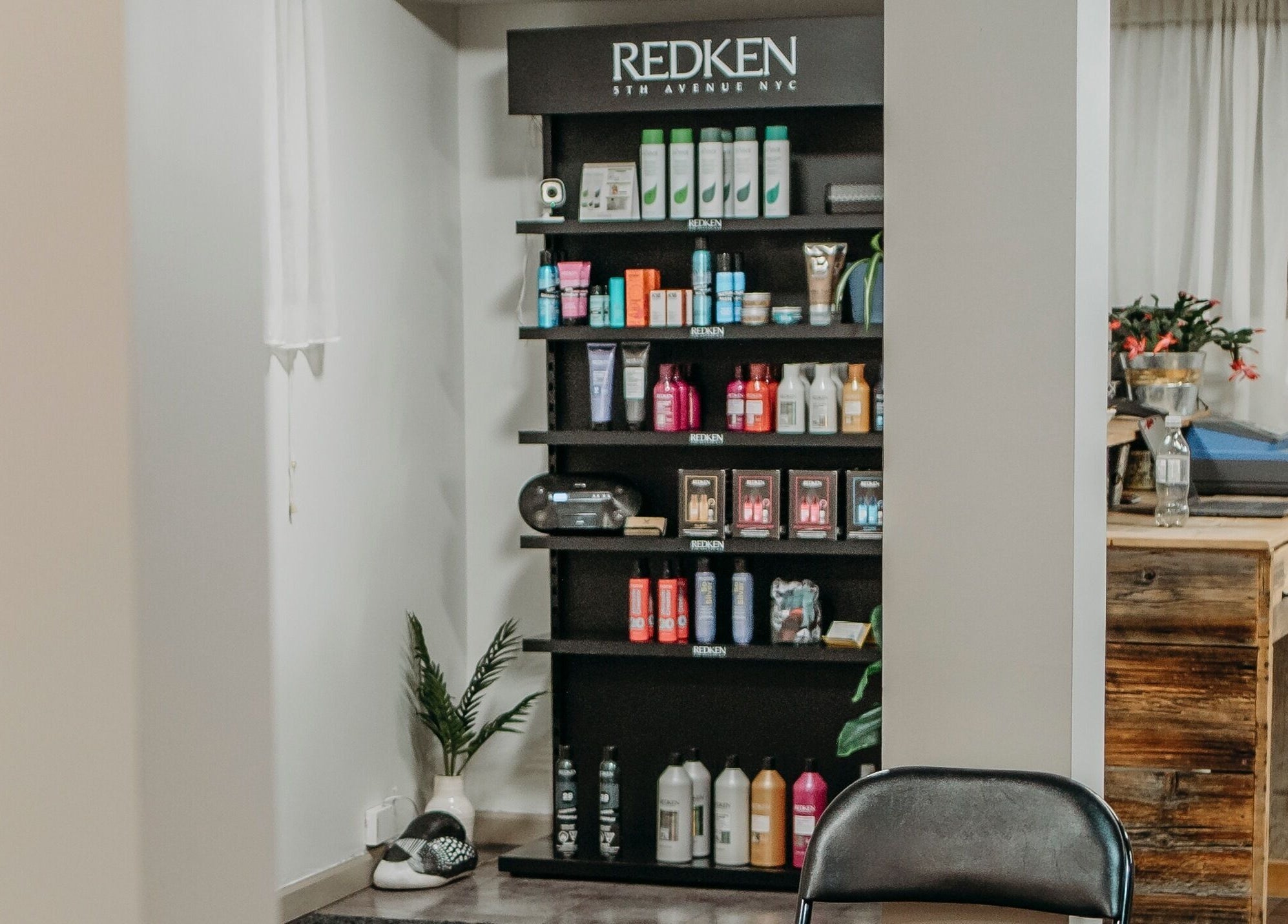 Product shelves at The Curly Temple Salon, Burns Lake, British Columbia, CA showcasing Redken items.