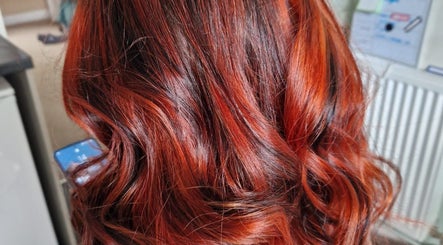 Vibrant red hair styled in waves at Beauty and Hair So Lovely, Braunstone Town, England, GB.