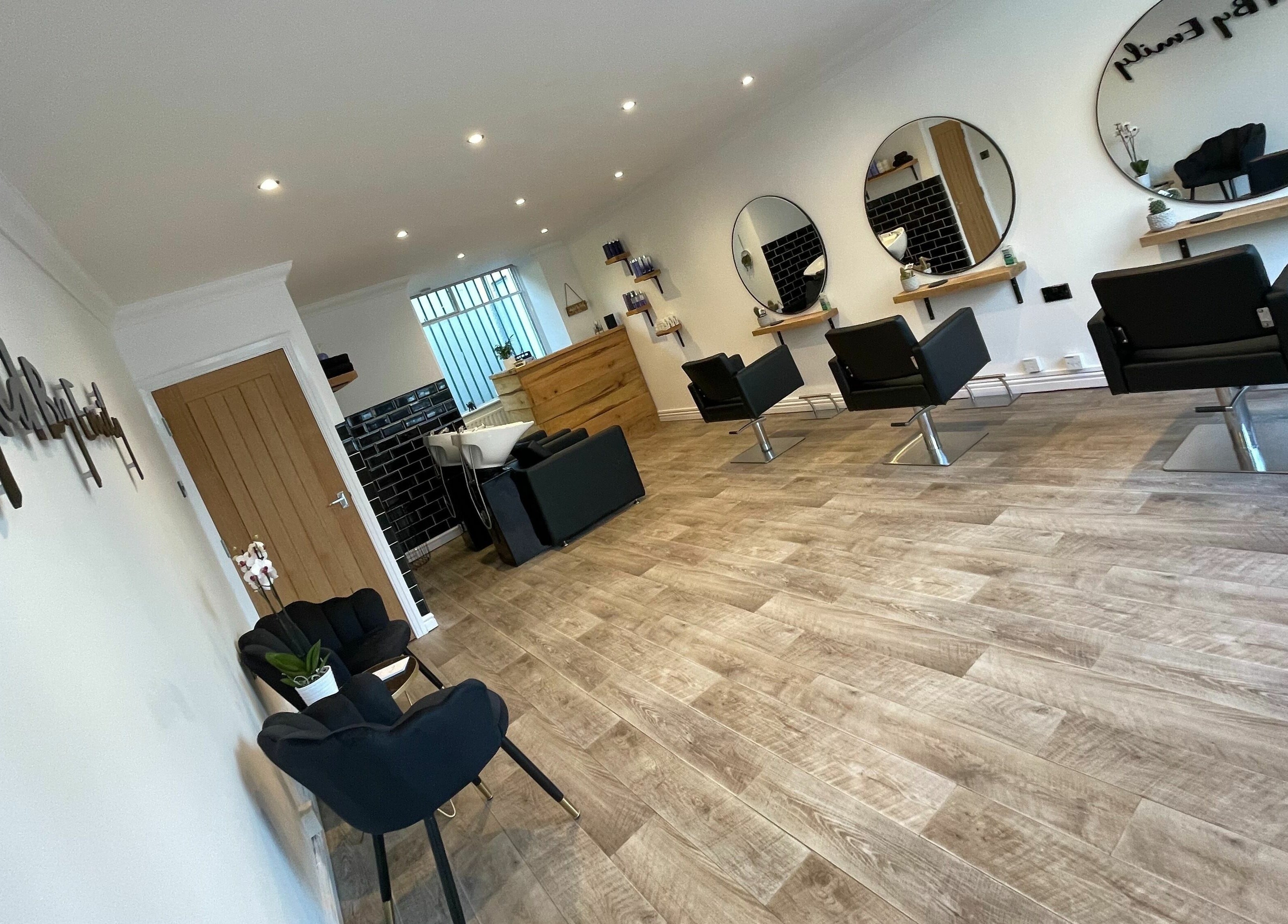 Styled By Emily LTD salon interior with sleek black chairs in Darwen, England, GB.