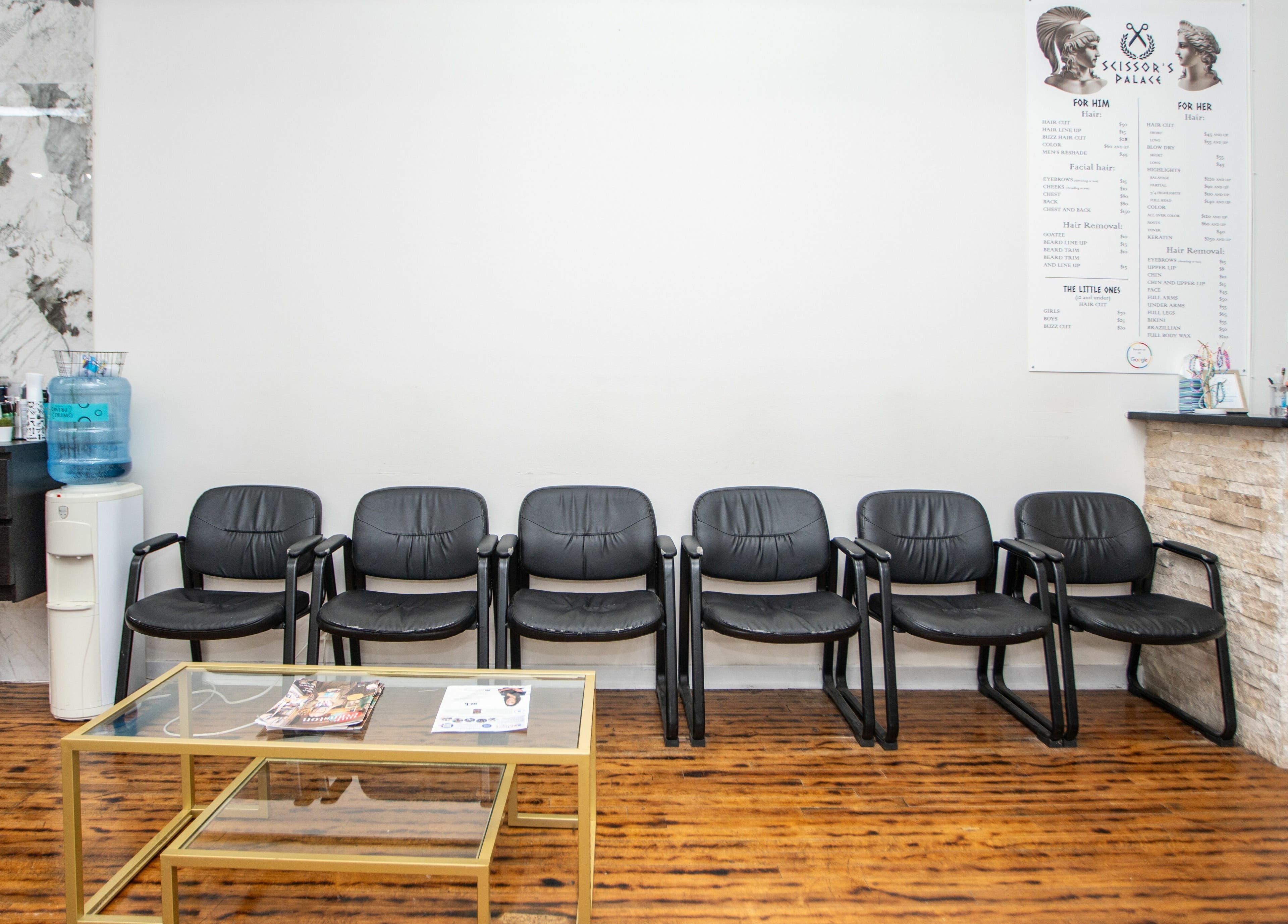 Elegant waiting area at Scissor's Palace in Evanston, Illinois, US, featuring stylish black chairs and a reception counter.