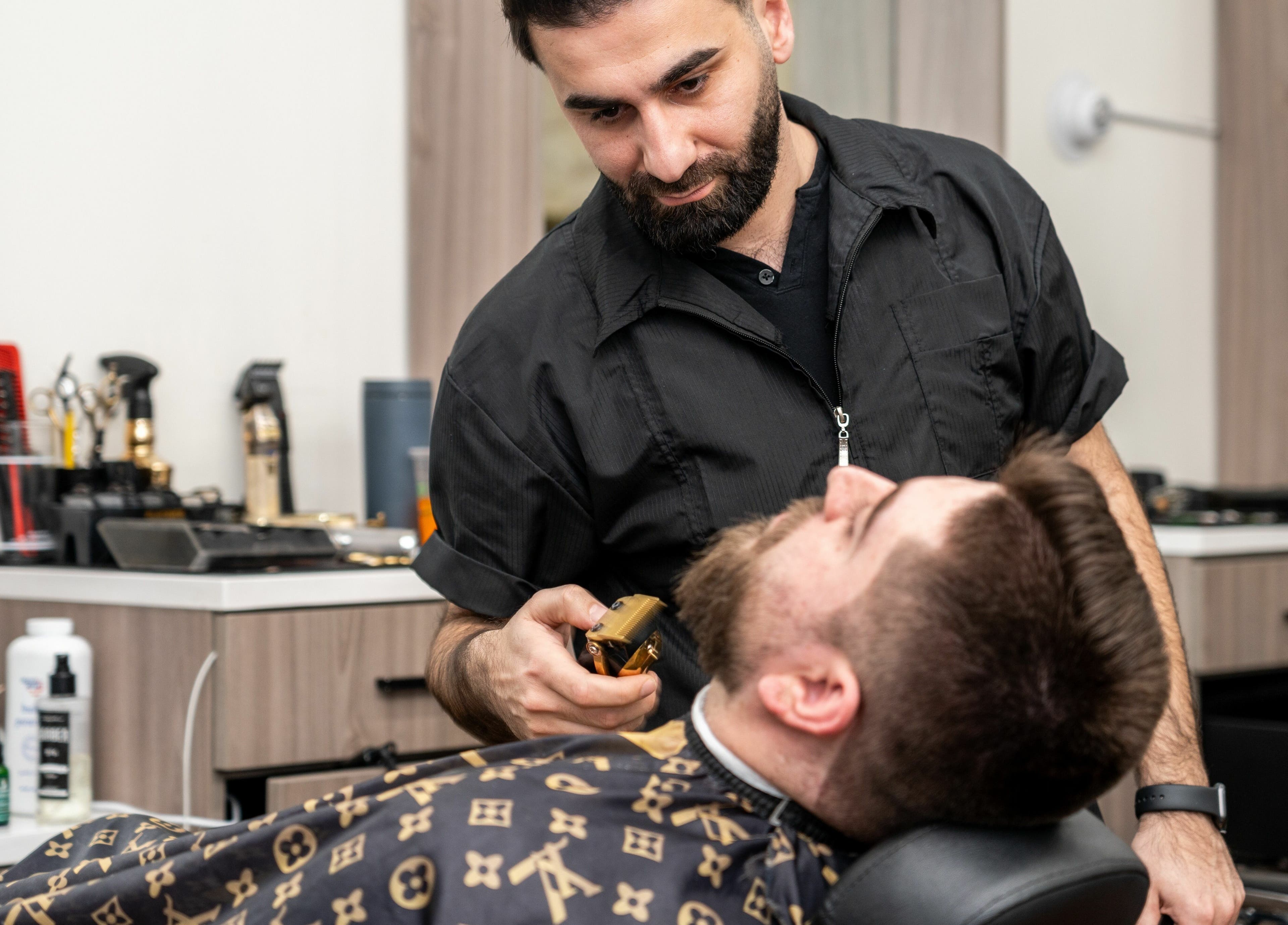 Barber styling a beard at Scissor's Palace in Evanston, Illinois, US with precision and care.