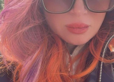 Stylish woman with vibrant pink and orange hair at Enchante Hair Nails Barber, Il-Mosta, MT.