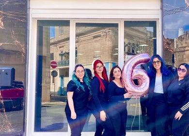 Team outside Enchante Hair Team Il-mosta MT celebrating with a balloon.