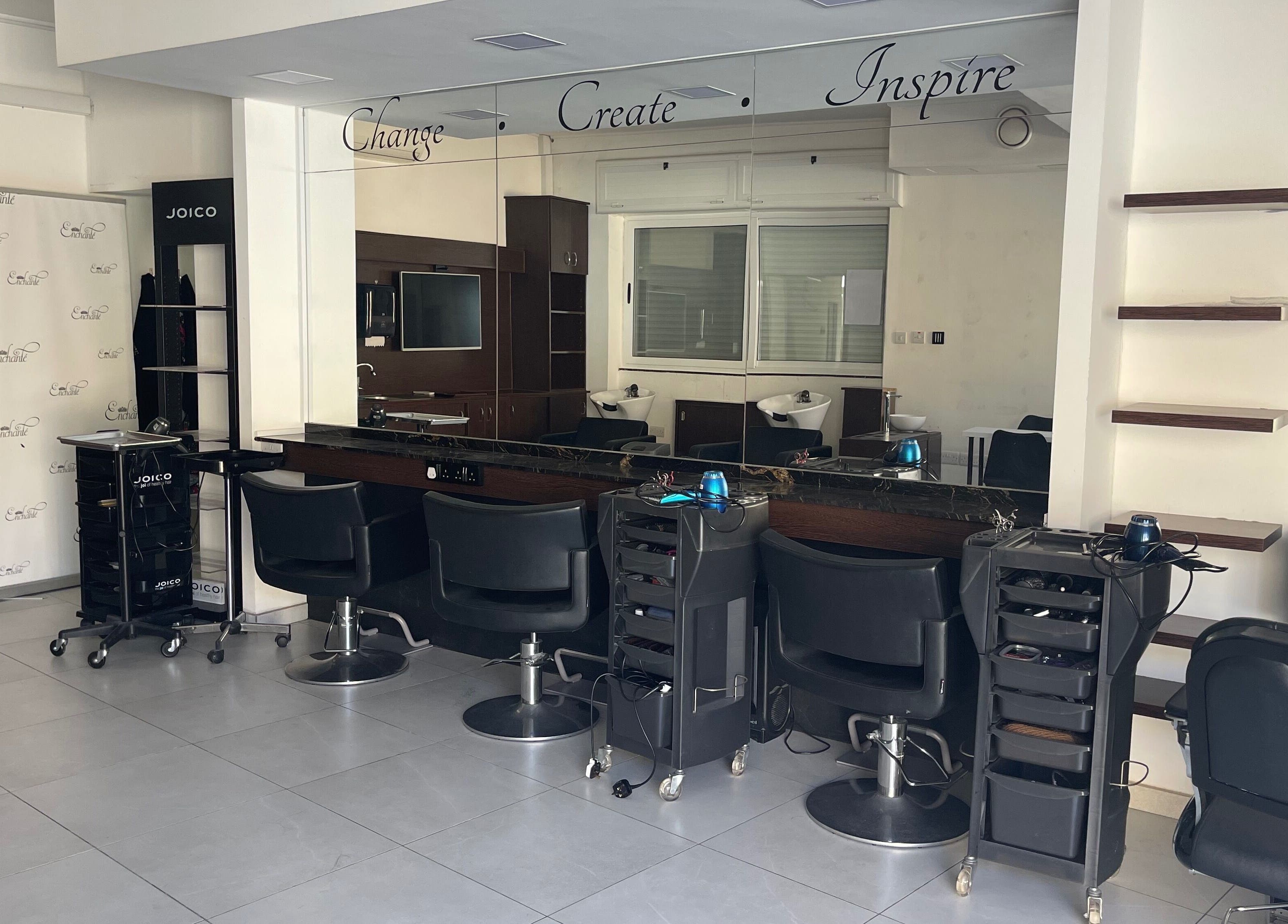 Modern salon interior at Enchante Hair Team, Il-mosta, MT, showcasing sleek styling stations and mirrors.