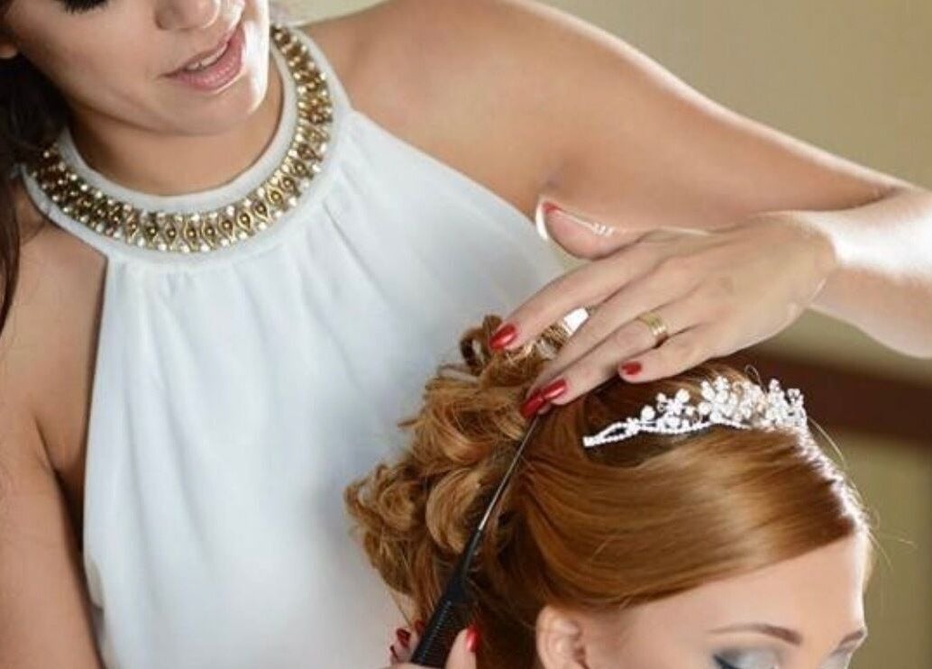 Stylist crafting a bridal updo at Enchante Hair Team, Il-mosta, MT with a tiara accent.