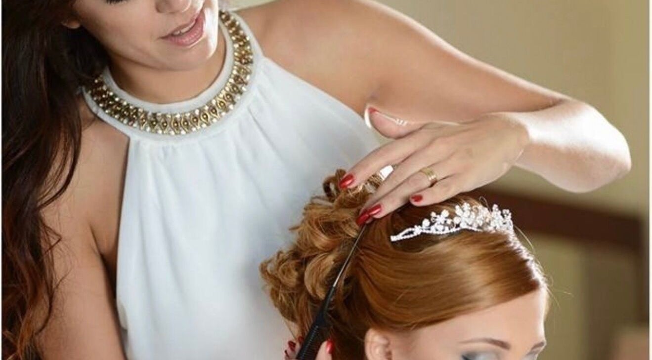 Stylist crafting a bridal updo at Enchante Hair Team, Il-mosta, MT with a tiara accent.