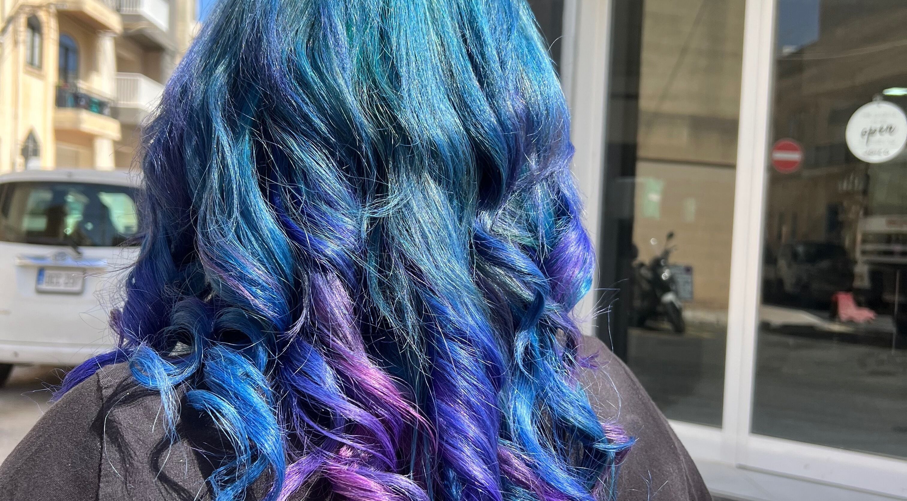 Vibrant blue and purple curls styled at Enchante Hair Team, Il-mosta, MT.