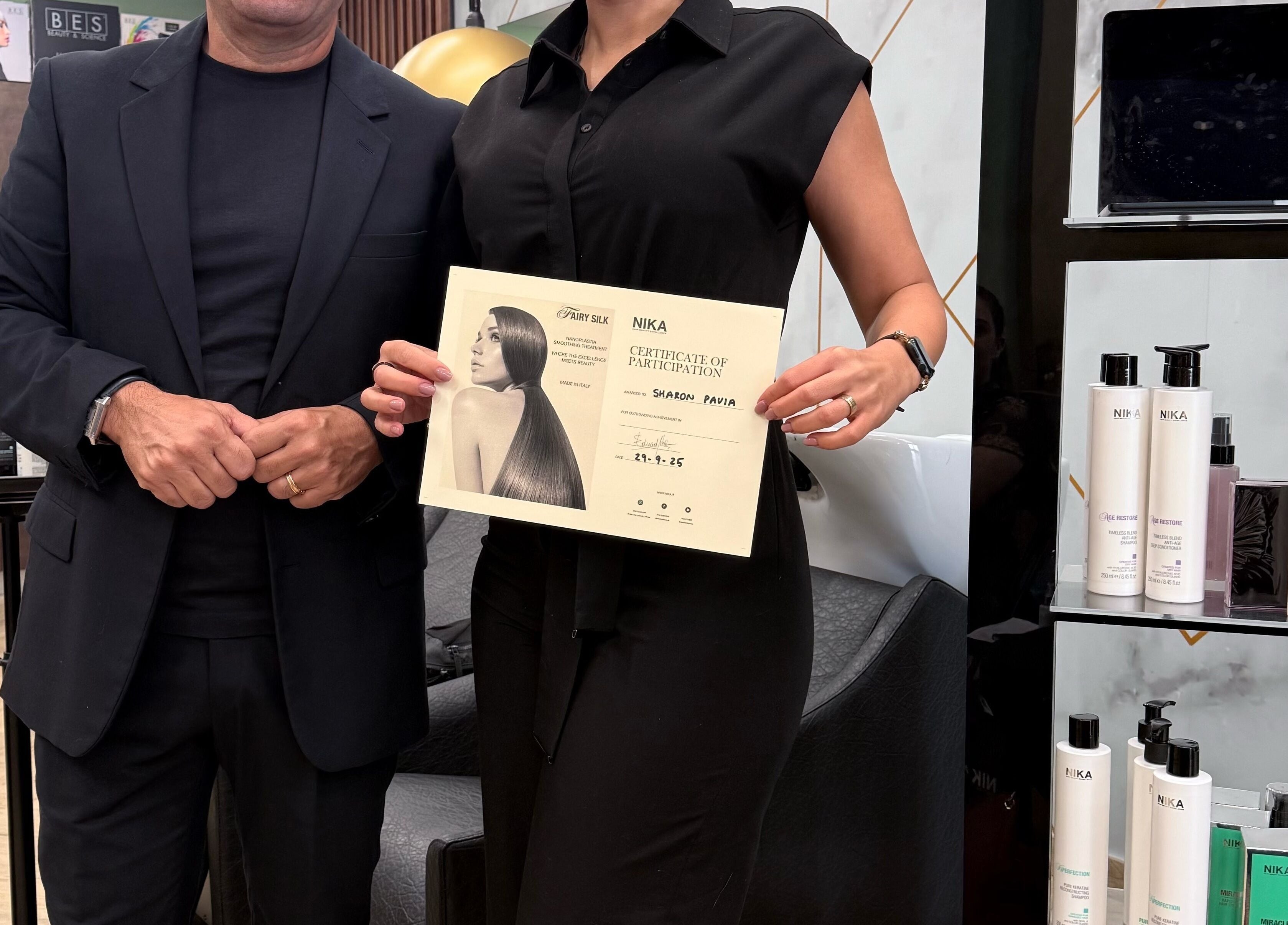Team member at Enchante Hair Team in Il-mosta, MT, proudly holding a participation certificate.