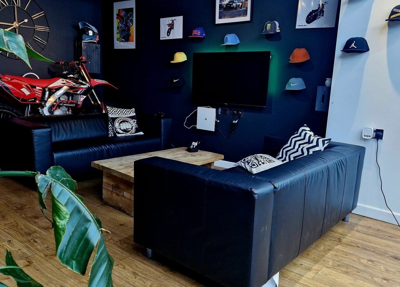 Modern lounge with leather sofas at Uppercut, Kilsyth, Scotland, GB. Showcasing decor like a clock and bike.