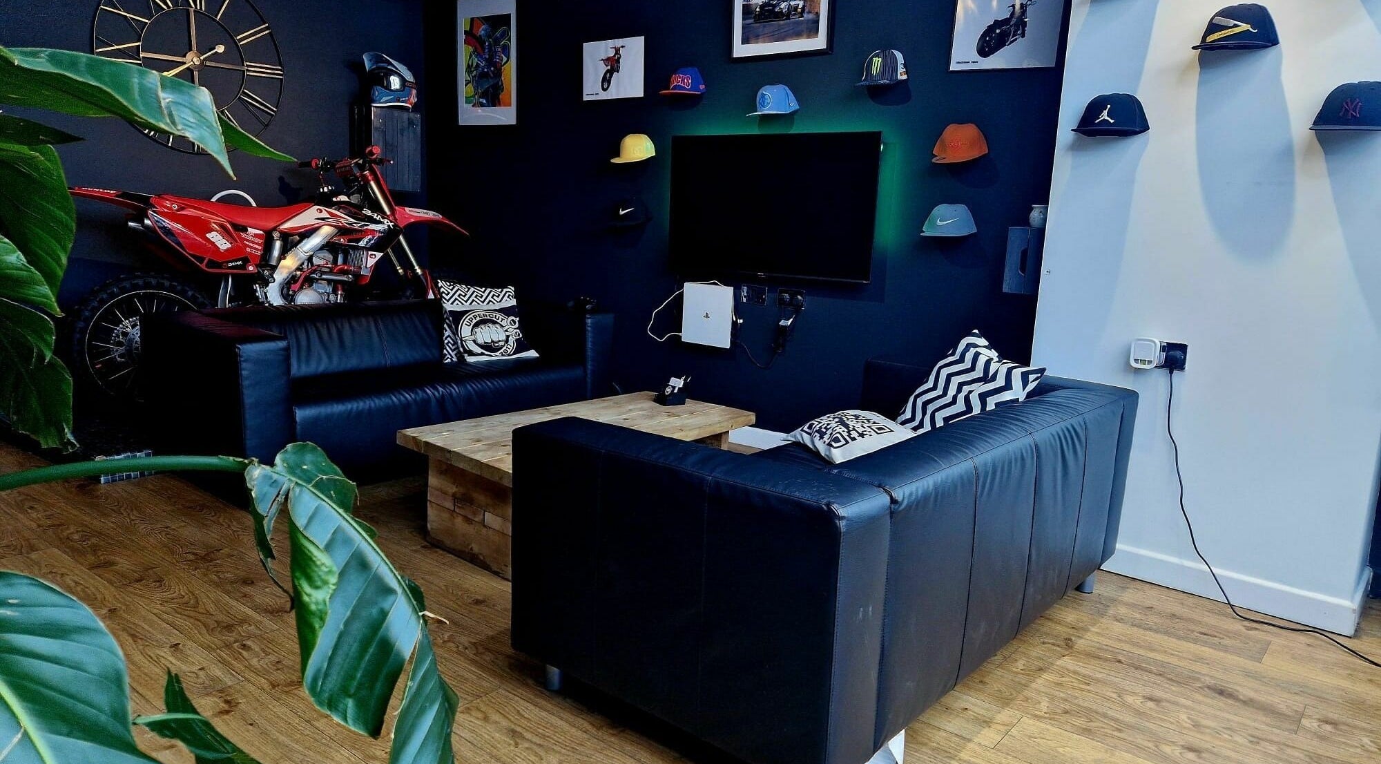 Modern lounge with leather sofas at Uppercut, Kilsyth, Scotland, GB. Showcasing decor like a clock and bike.