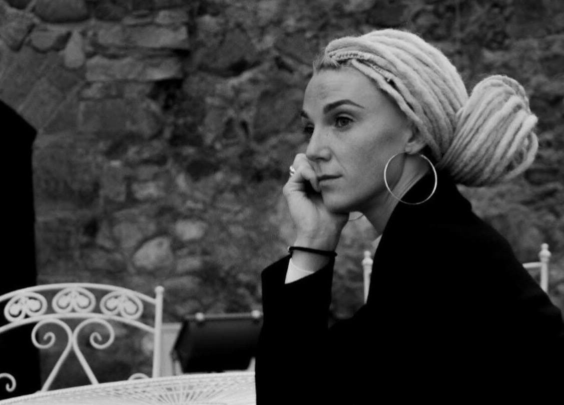 A stylish woman with intricate braids at FOXY Braid House, Rīga, LV, enjoying a serene moment.