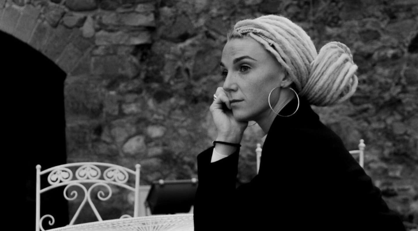 A stylish woman with intricate braids at FOXY Braid House, Rīga, LV, enjoying a serene moment.