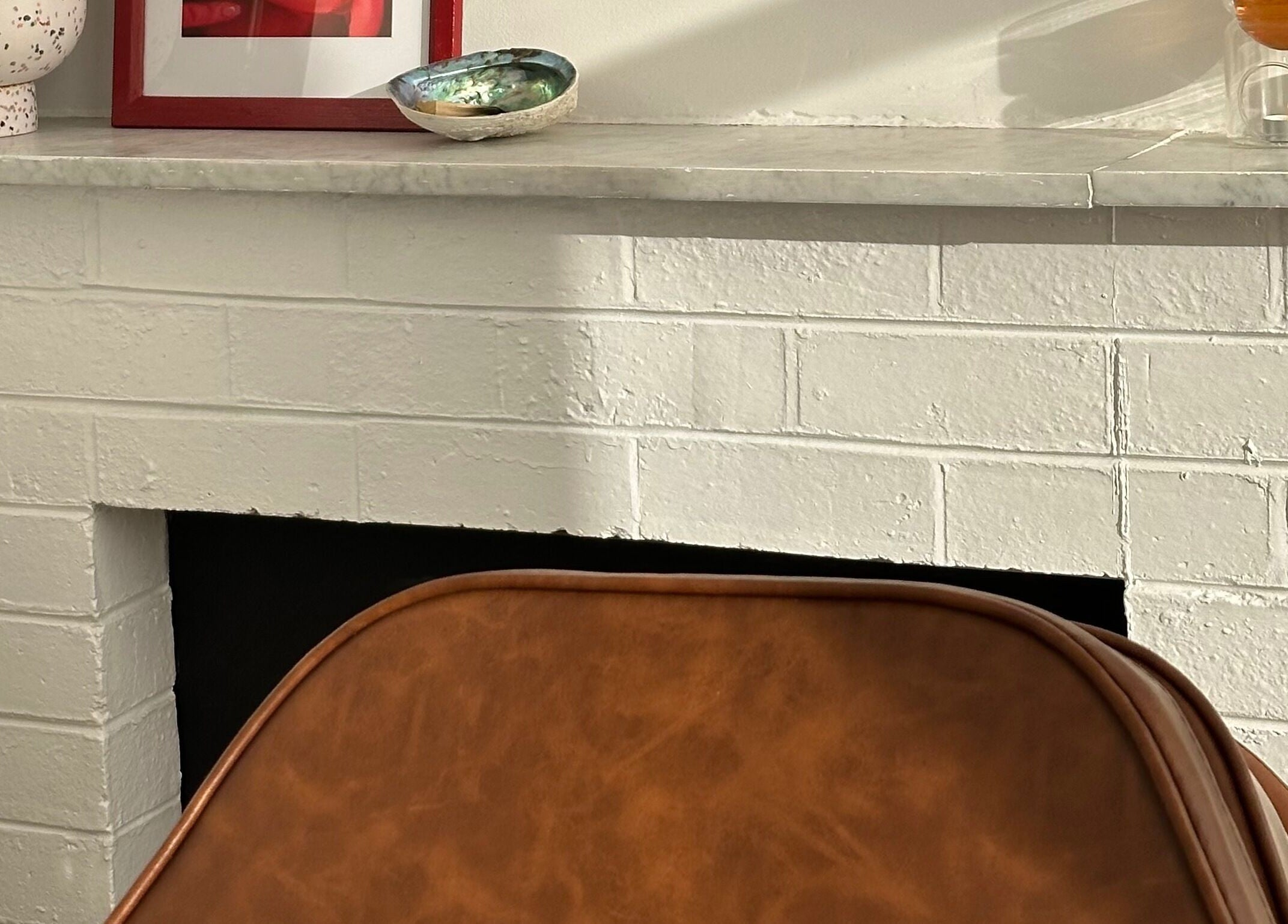 Chic fireplace corner at Néktar Studio, Melbourne, Victoria, AU with decor and cozy chair for relaxation.