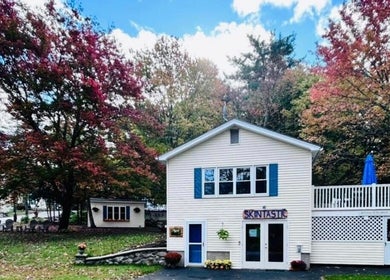 Skintastic Skin Care’s Lake Side Escape in Raymond, NH, surrounded by vibrant fall foliage and a peaceful setting.
