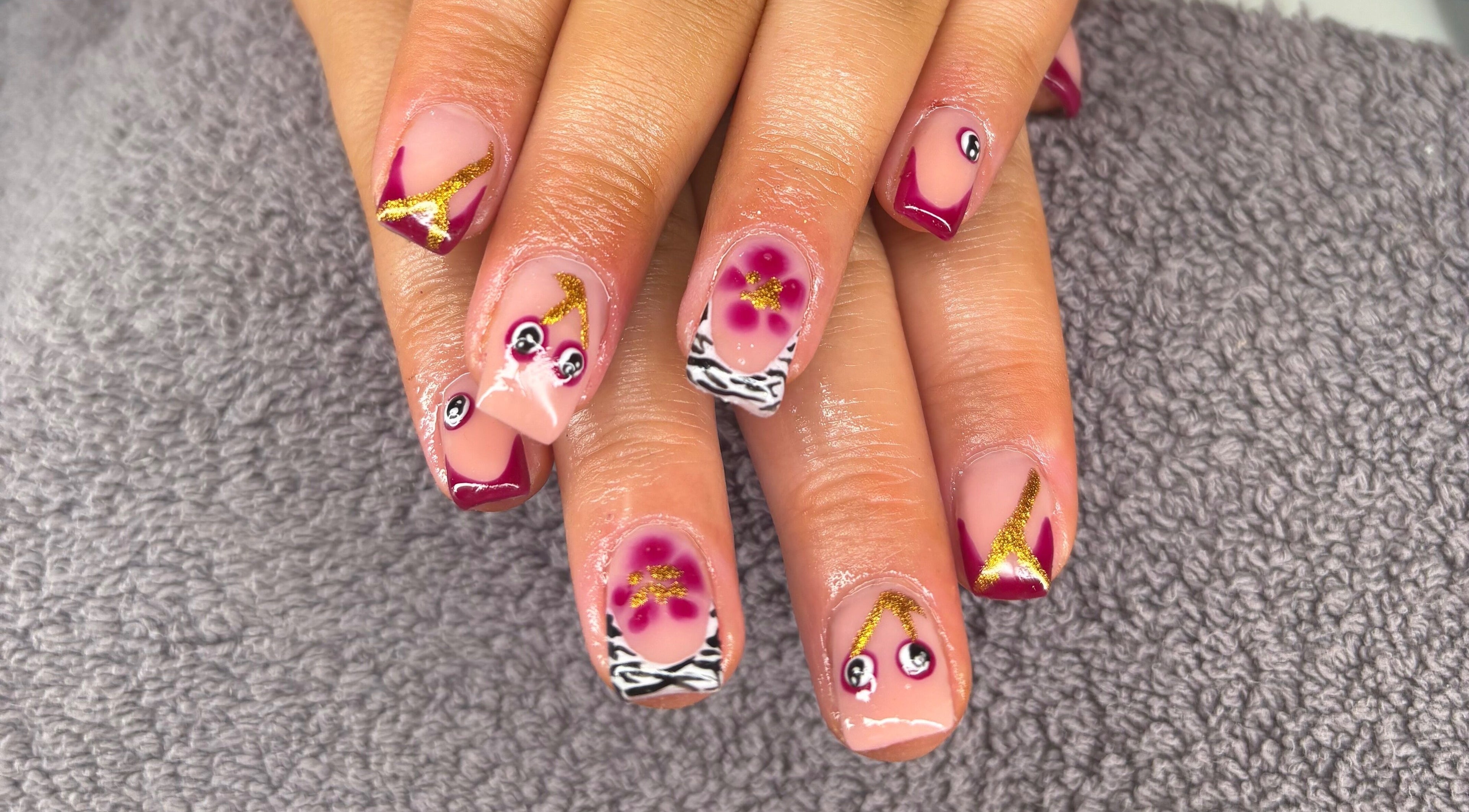 Intricate nail art at The Beauty Loft, Stanley, England, GB featuring vibrant designs on polished nails.