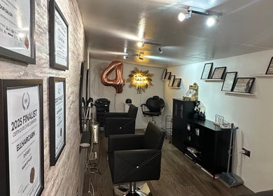 Ellhaircabin interior in Derby, England, showcasing awards and styling chairs in a modern salon setting.