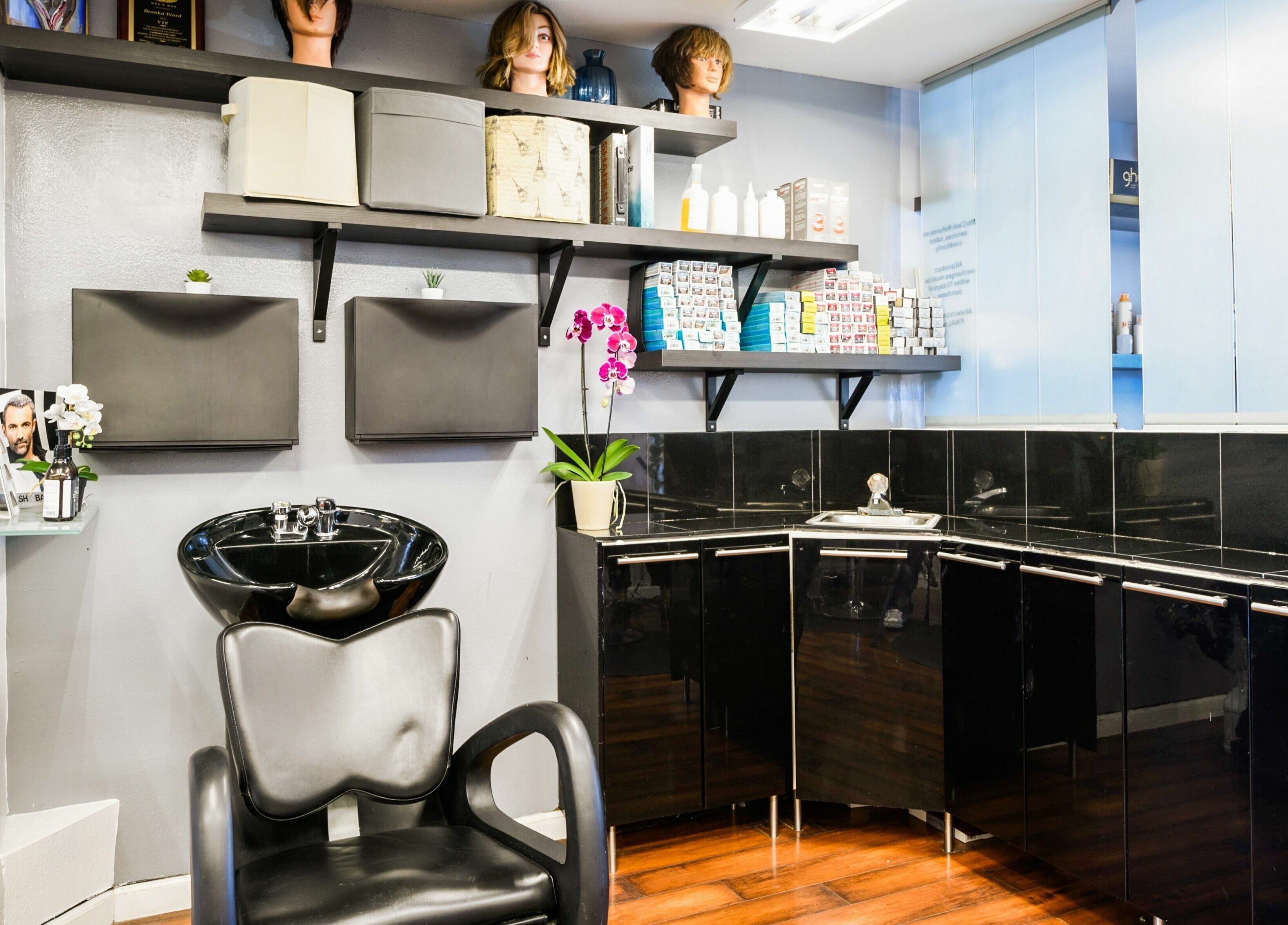 Modern wash station at Mud Honey Salon, Manhattan Beach, California, US. Sleek design with storage and orchid decor.
